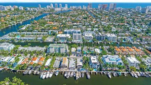 Una marina con numerosos barcos amarrados, rodeada de edificios residenciales y un horizonte urbano al fondo.