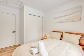 A bedroom with a bed, a nightstand, a lamp, and a painting on the wall. - Amira | Nature Retreat | Hiking (Brownsburg)