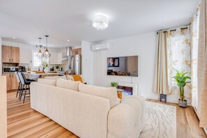 Uma sala de estar moderna com sofá, televisão e lareira.
