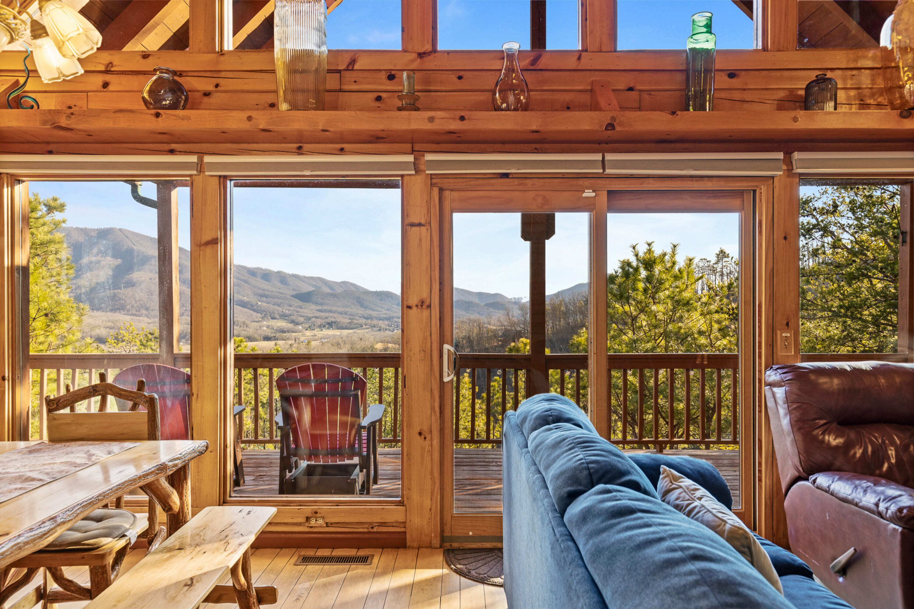 A wooden deck with a table, chairs, and a sofa.
