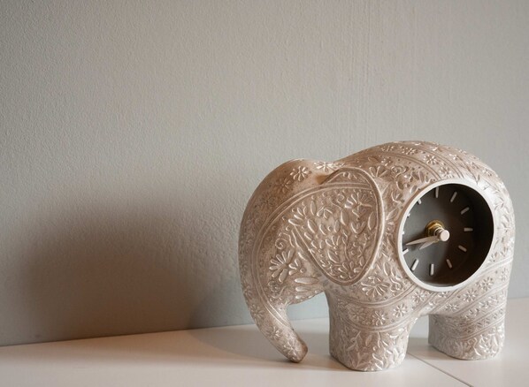 Une horloge décorative en forme d’éléphant, ornée de motifs floraux complexes.