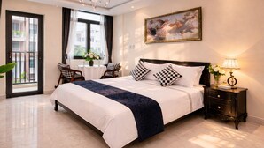 Een hotelkamer met een groot bed, een kroonluchter, een nachtkastje en een schilderij aan de muur.