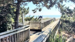 Une promenade en bois mène à une plage, et un panneau indique qu’il s’agit d’une zone protégée.