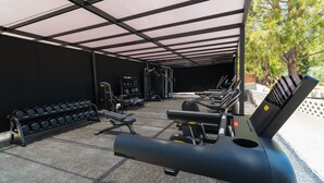 A covered outdoor gym area with exercise equipment, including treadmills and dumbbells. - Cabú Hotel Adults Only (Rhodes)