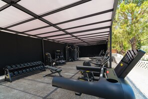 A covered outdoor gym area with exercise equipment, including treadmills and dumbbells. - Cabú Hotel Adults Only (Rhodes)