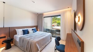 A modern hotel room with a bed, bedside table, and a desk with a chair. - Cabú Hotel Adults Only (Rhodes)