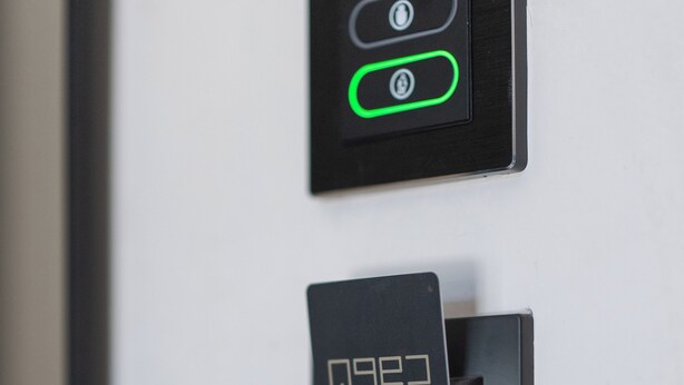 Et kontrolpanel med to oplyste knapper, et digitalt display og en kortlæser.