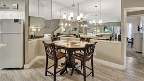 A modern kitchen with a central island, wooden chairs, and pendant lighting. - 52 Ocean Breeze: Free Bikes, Tennis & Pool, Pet Friendly! (Hilton Head Island)
