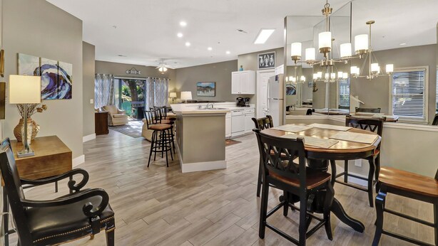 A modern kitchen with a central island, dining area with wooden chairs, and a living room with a sofa and a coffee table. - 52 Ocean Breeze: Free Bikes, Tennis & Pool, Pet Friendly! (Hilton Head Island)