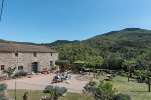 A stone building with a patio area where people are seated.