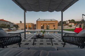 An outdoor patio with a pool, lounge chairs, and a covered seating area. - Villa Dide Moga Zadarvillas (Sveti Filip i Jakov)