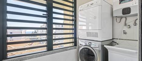 A laundry room with a washing machine, dryer, and stacked washer-dryer unit.