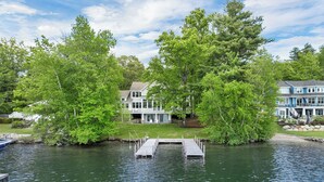 Propiedad junto al lago con acceso a muelle, árboles grandes y dos casas de varias plantas.