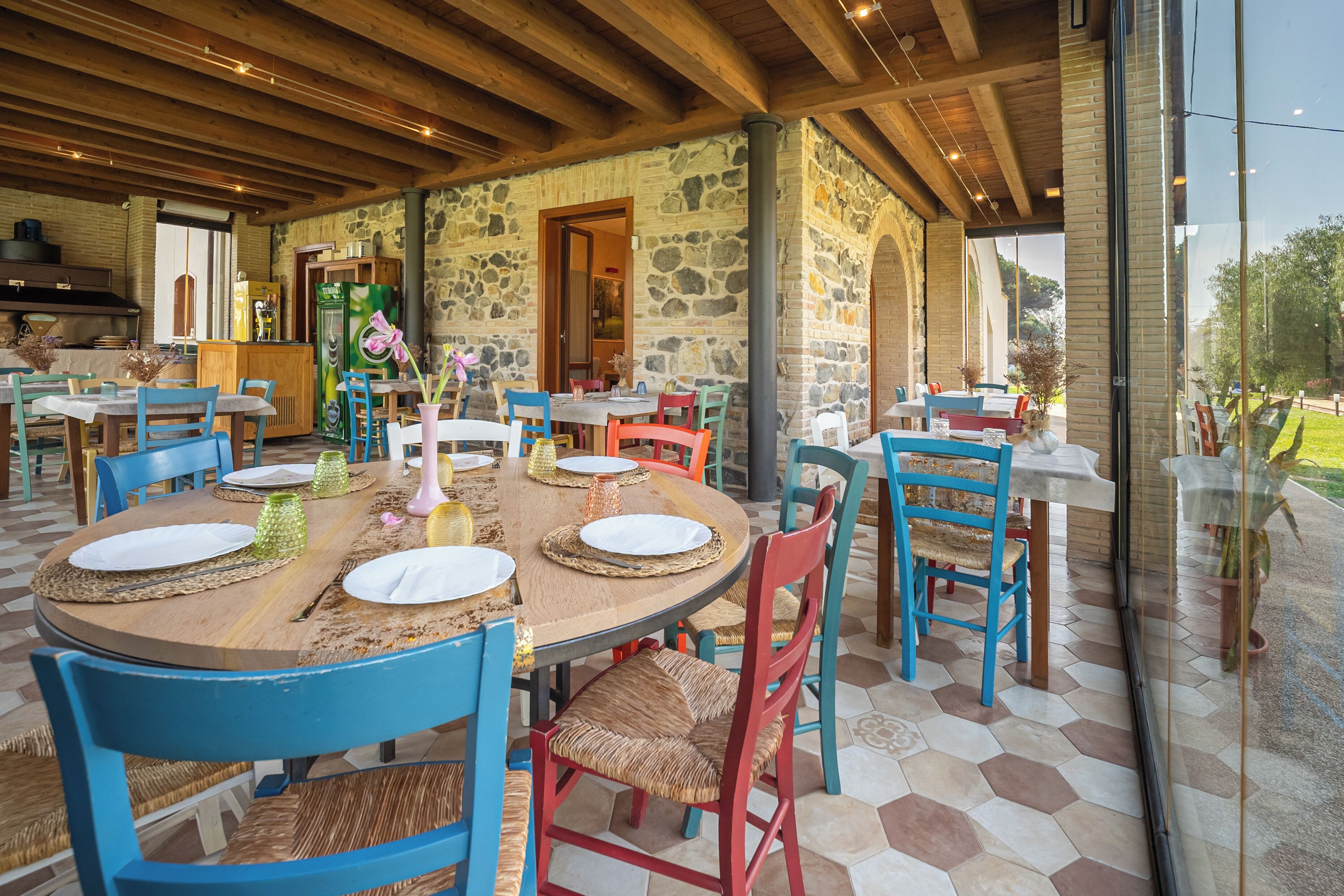 A restaurant with stone walls, wooden tables, and chairs.