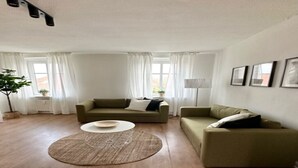 A living room with two sofas, a coffee table, and a floor lamp. - Arbio Monteurzimmer Tremmen 6 people (Ketzin)