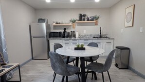 Una cuina moderna amb taula rodona, caires grisos i forn integrat.
