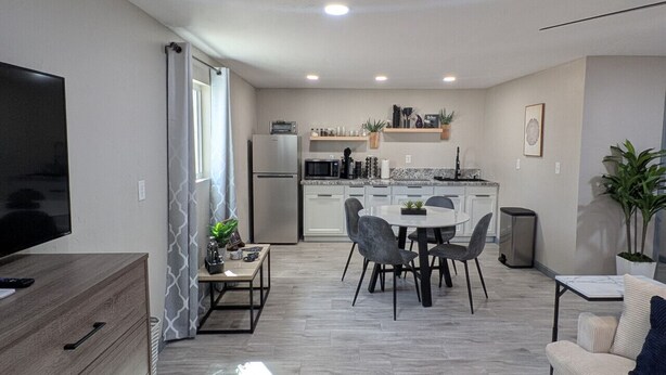 Un apartament modern amb zona de menjador, cuina i saló.