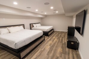 A bedroom with two beds, a flat-screen TV, and a storage unit. - Lakefront Tech-savvy Home with Seasonal Pool & Hot Tub (La Porte)