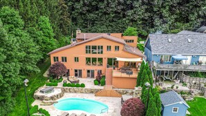 Une grande maison avec une piscine, un patio couvert et une maison d’hôtes séparée.