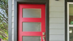 A red door with a glass panel, a doormat with "HOME" written on it, and a small window above the door. - Secluded Guest House in beautiful setting (Austin)