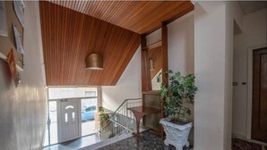 A modern interior with a wooden ceiling, a staircase, and a potted plant. - Acropolis Vista Retreat (Athina)