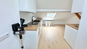 A compact kitchen with a skylight, a sink, and a coffee machine.