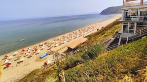 Una playa con sombrillas y una torre de salvavidas.