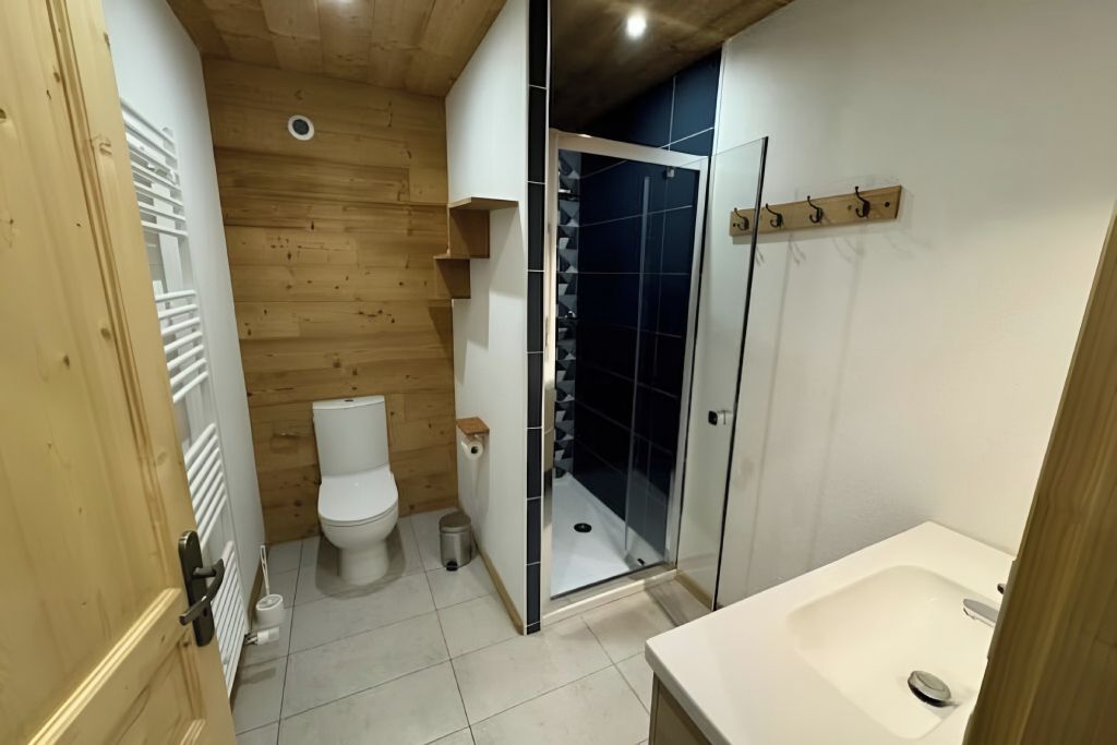 Een badkamer met toilet, douche en wastafel.