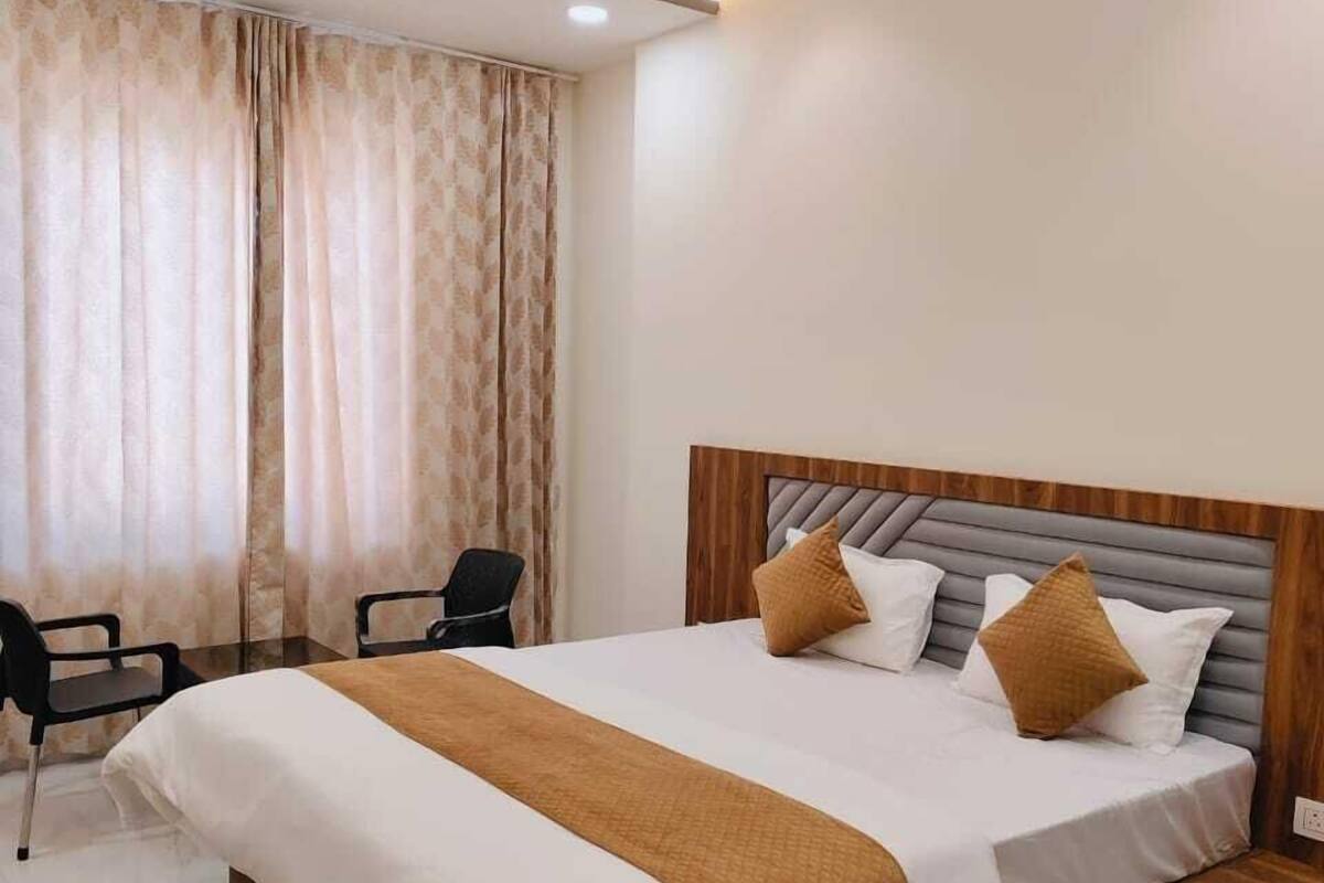 A modern hotel room with a large bed, a ceiling fan, and a desk with chairs.