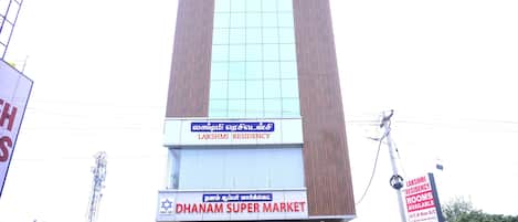 A building with signs for Lakshmi Residency and Dhanam Super Market.