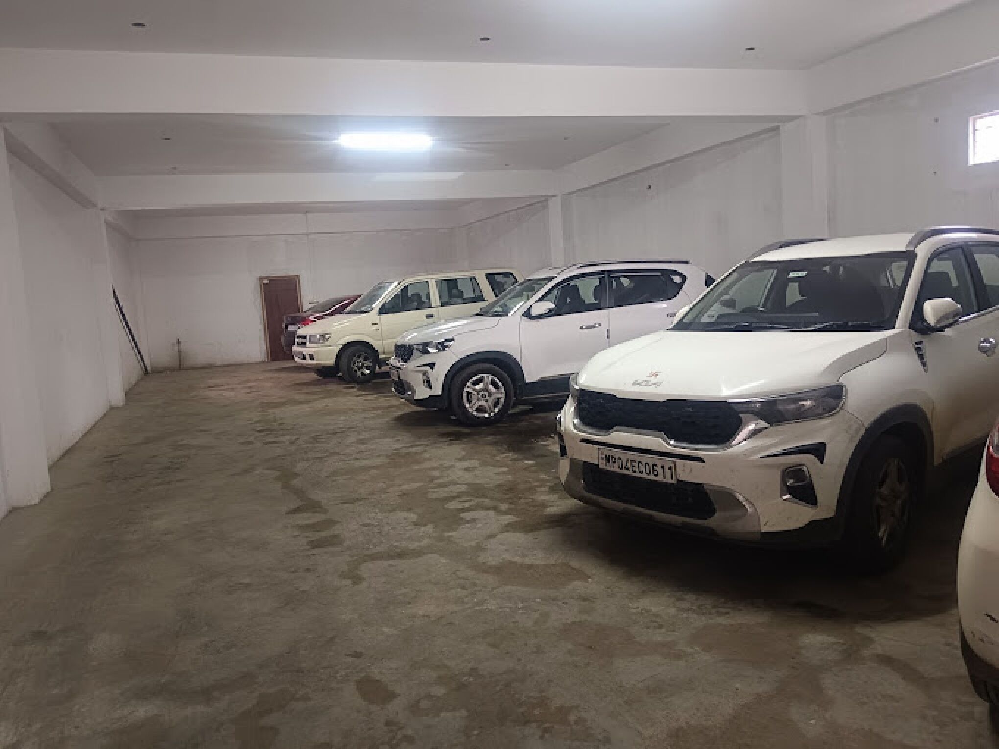 Un parking où sont garés, en rangées, des véhicules tout-terrain blancs.