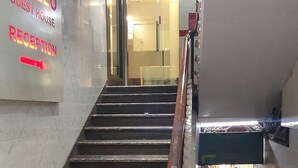 A staircase leading to a hotel reception area with a sign for the Apollo Guest House. - Apollo Guest House – Colaba Causeway (Mumbai)