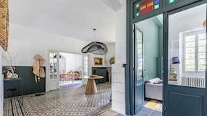 A modern interior with a patterned floor, a dining area, and a sofa in the background.