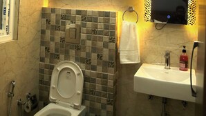 A bathroom with a toilet, sink, and shower. - Casa Central (New Delhi)