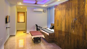 A bedroom with a bed, a desk, a wardrobe, and a ceiling fan. - Casa Central (New Delhi)