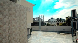A rooftop terrace with a patterned wall, air conditioning units, and a clear sky. - Casa Central (New Delhi)