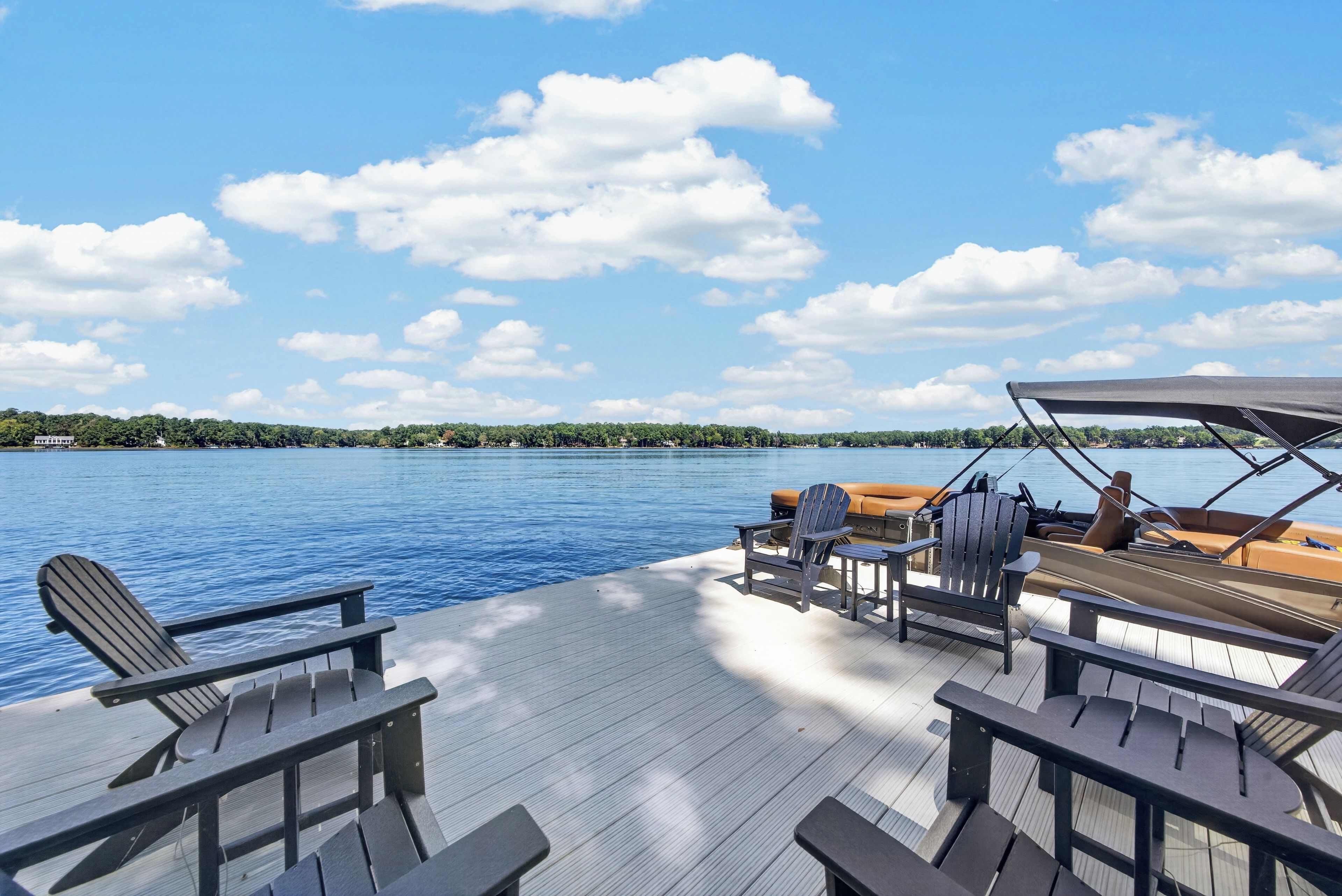 A boat deck with seating and a view of a calm lake.