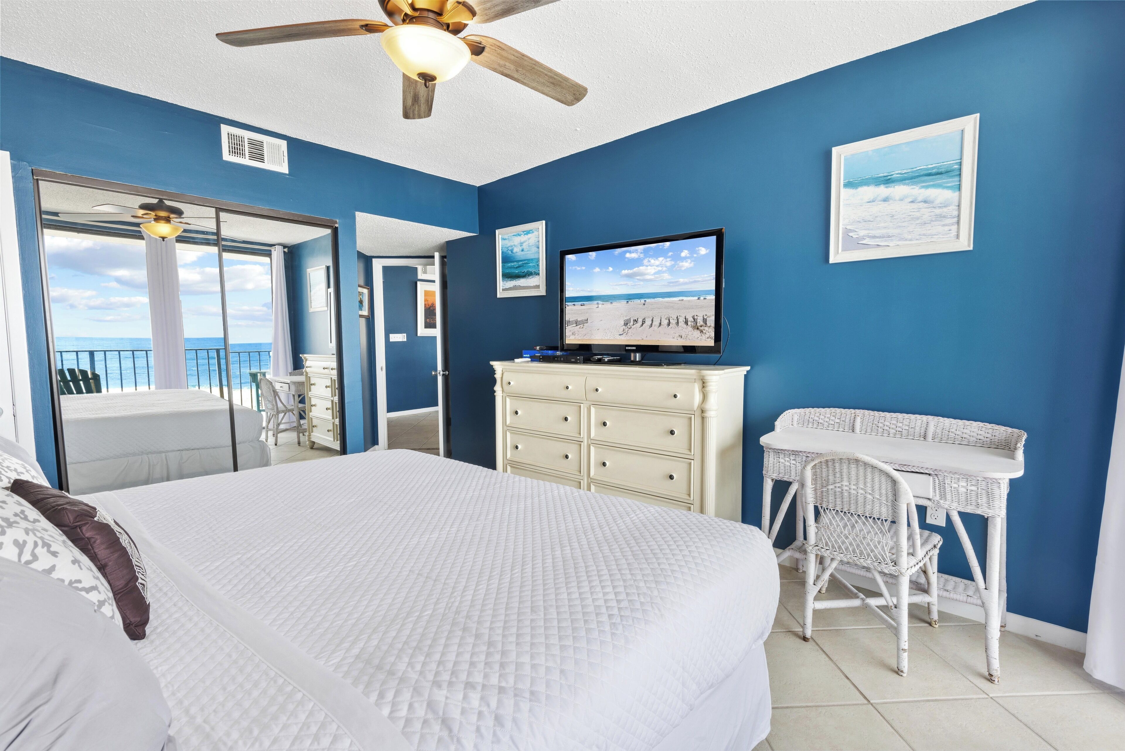 Une chambre à coucher comprenant un lit, une télévision, une commode et un bureau avec une chaise.