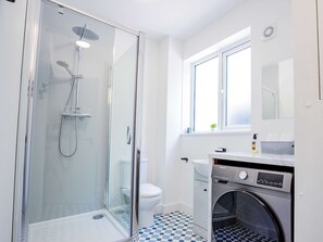 Enjoy a refreshing shower experience with a handheld and rain showerhead, plus convenient self-service laundry facilities.
