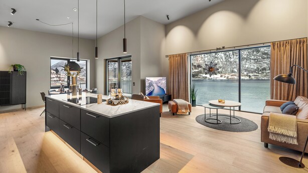 A modern living room with a large window, a sofa, a coffee table, and a TV. - Penthouse with amazing fjord view (Vestland)