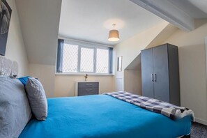 A bedroom with a bed, a wardrobe, a desk, and a window. - Host & Stay | Park Cliffe House (Bradford)