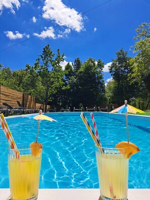 A swimming pool with two drinks in front of it. - Apartments Villa Mavi (Rakovica)