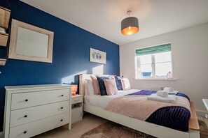 A bedroom with a bed, bedside table, dresser, and a window with curtains. - Host & Stay | Mercia House (Kempsey)