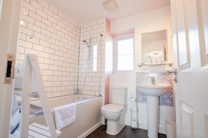 A modern bathroom with a shower, toilet, and sink.
