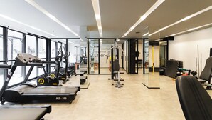 A modern gym with treadmills, weight machines, and exercise equipment.