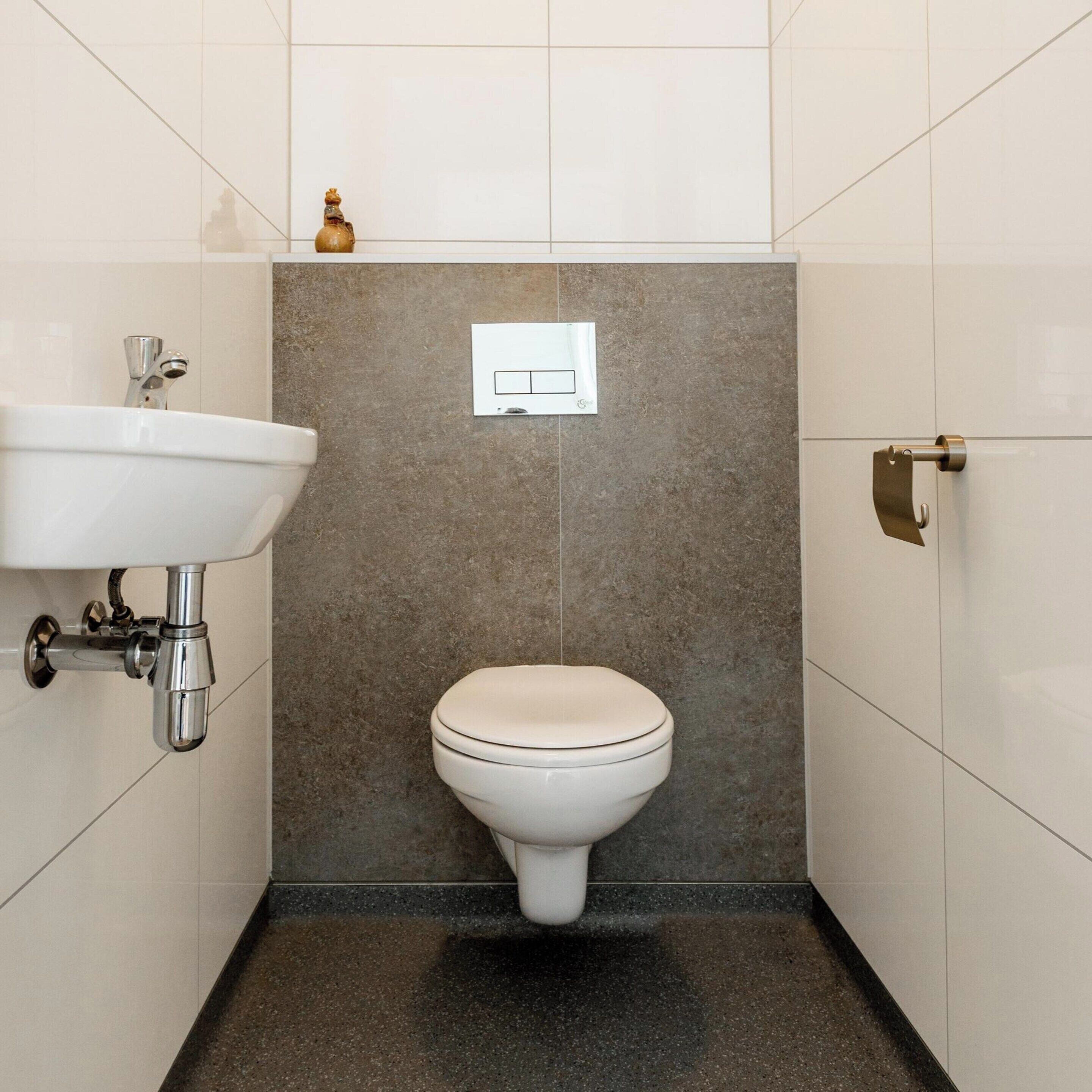 A bathroom with a white sink, a toilet, and a towel rack.