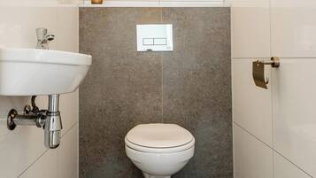 A bathroom with a white sink, a toilet, and a towel rack.
