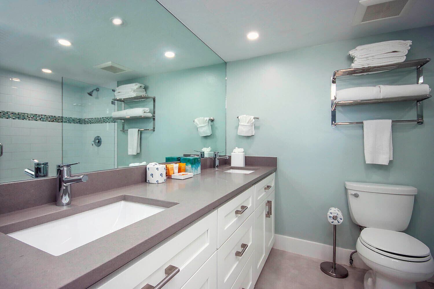 Un baño moderno con un lavamanos grande, un inodoro y un espejo.