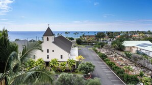A church with a cross on top, surrounded by a parking lot and greenery. - Kailua Village#705 Top Floor, Gorgeous Remodeled 2 bedroom, in Heart of Town (Kailua Kona)