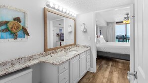 Een moderne badkamer met een grote spiegel, een wastafel en uitzicht op het balkon.